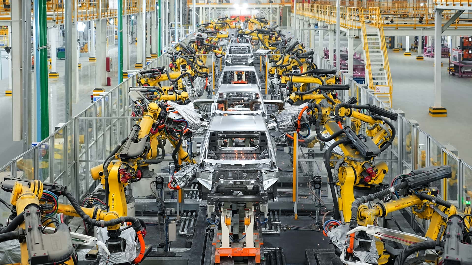 Robotic arms assembling electric vehicles on BYD's factory line